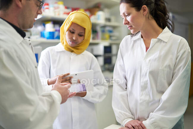 Scientists with specimen tray in laboratory — Stock Photo