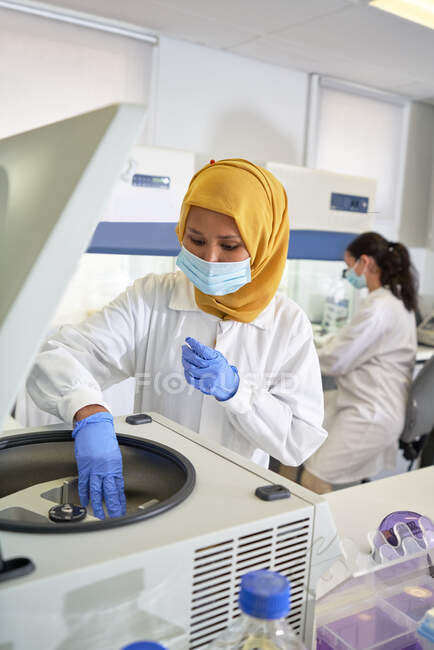 Wissenschaftlerin im Hijab und Gesichtsmaske mit Zentrifuge im Labor — Stockfoto