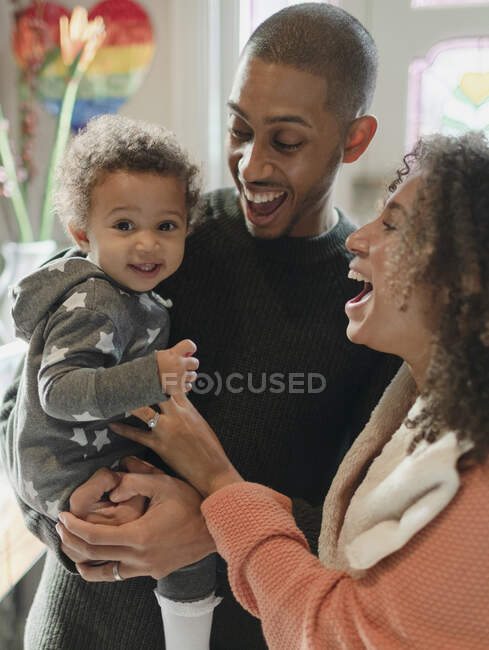 Portrait happy parents and baby daughter laughing — Stock Photo