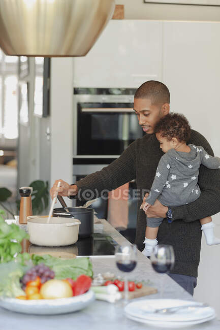 Pai e bebê filha cozinhar no fogão de cozinha — Fotografia de Stock