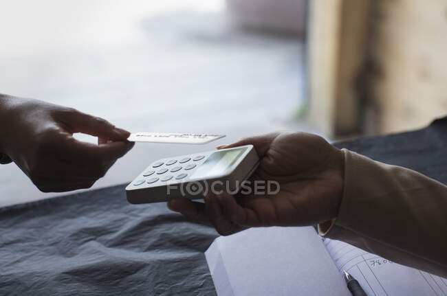 Close up shop owner holding credit card reader for customer — Stock Photo