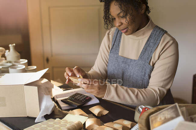 Female shop owner preparing boxes for shipping — Stock Photo