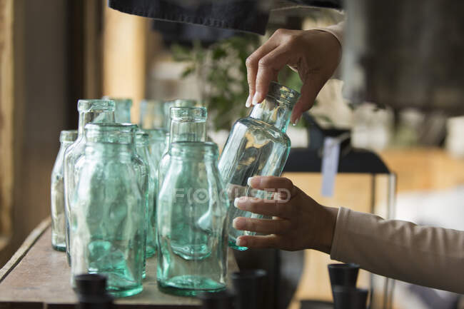 Verkäuferin richtet Flaschenauslage im Geschäft ein — Stockfoto