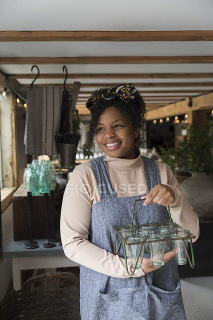 Portrait heureux propriétaire de magasin femme tenant porte-plantes en verre — Photo de stock