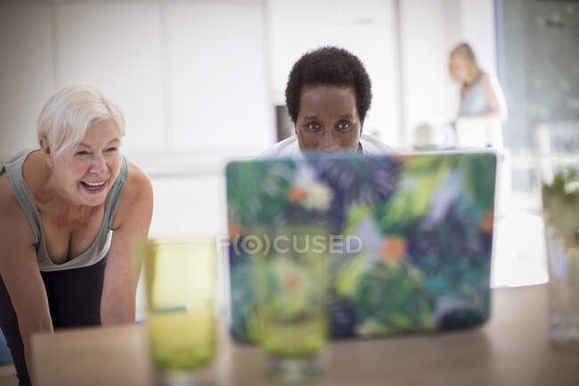 Senior women friends exercising at laptop — Stock Photo