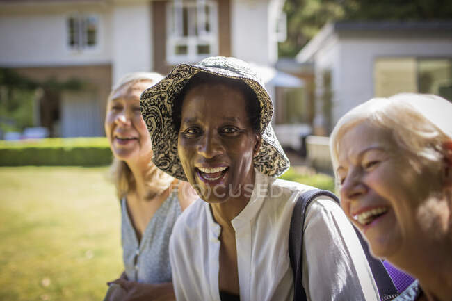 Portrait happy senior women friends in sunny summer backyard — Stock Photo