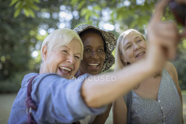 Joyeuses amies aînées prenant selfie dans le parc — Photo de stock