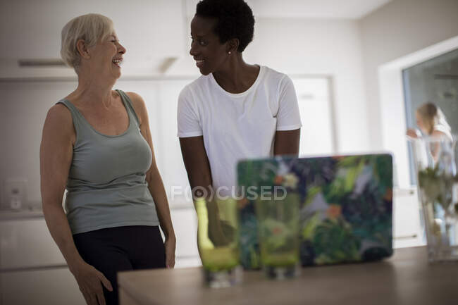 Happy senior women friends exercising at laptop in dining room — Stock Photo