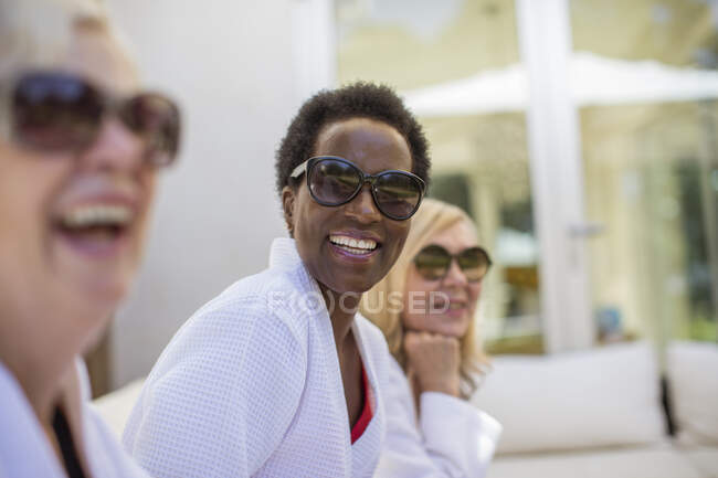 Portrait happy senior women friends in spa bathrobes and sunglasses — Stock Photo