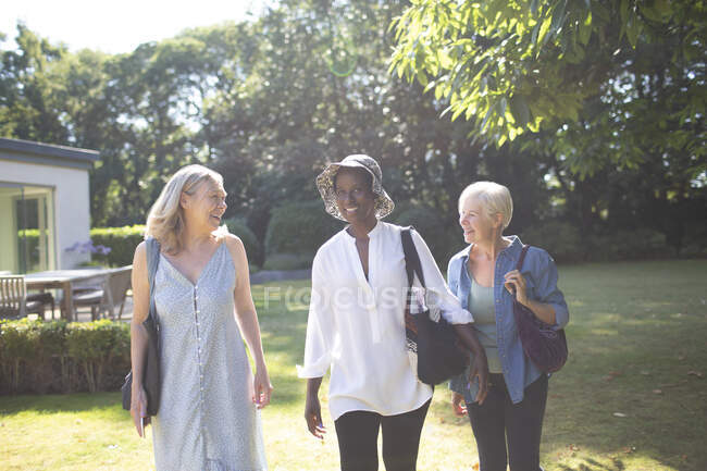 Щасливі старші жінки друзі ходять в сонячному літньому саду — стокове фото