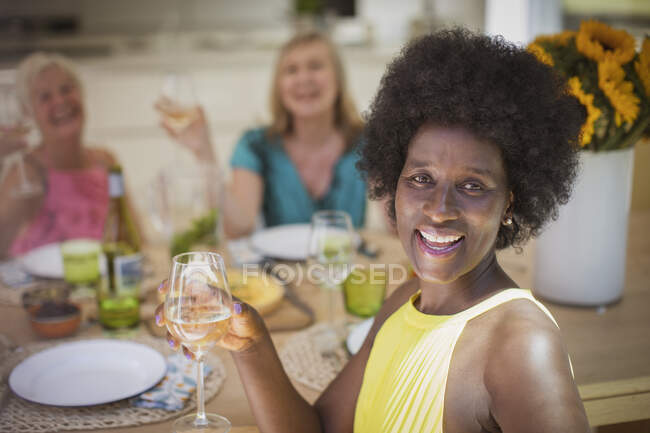 Retrato feliz senior mujeres amigos disfrutando del vino en el almuerzo - foto de stock