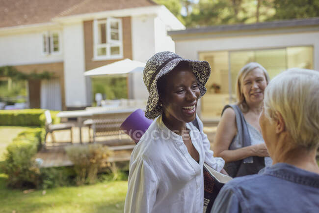 Счастливые пожилые женщины с ковриком для йоги в летнем саду — стоковое фото