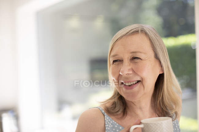 Ritratto felice donna anziana bere il tè a casa — Foto stock