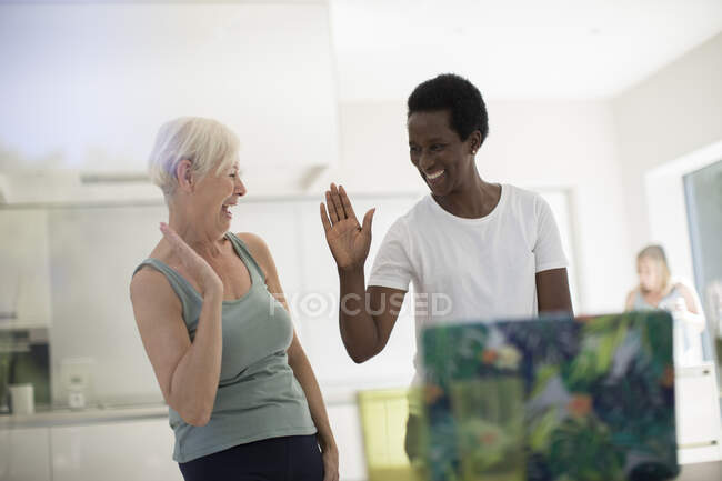 Happy senior women friends high fiving after online workout — Stock Photo