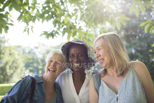 Portrait happy senior women in sunny summer garden — Stock Photo