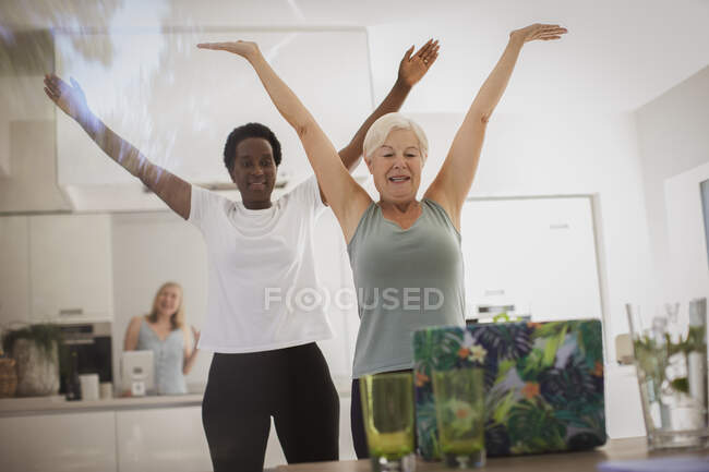 Senior women friends exercising online at laptop in dining room — Stock Photo