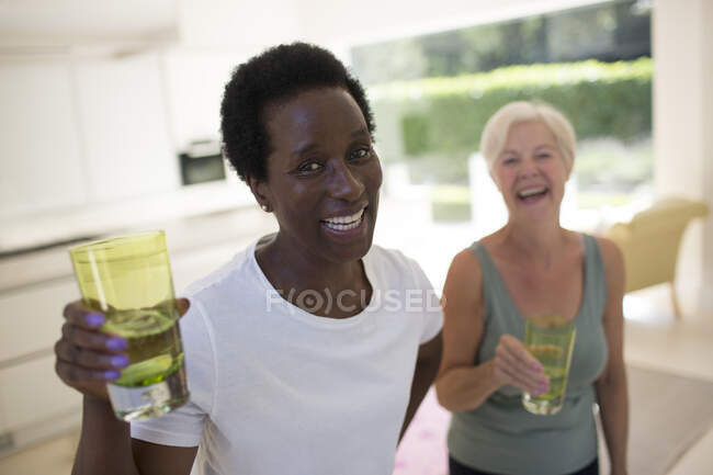 Portrait confident senior women friends drinking water after workout — Stock Photo