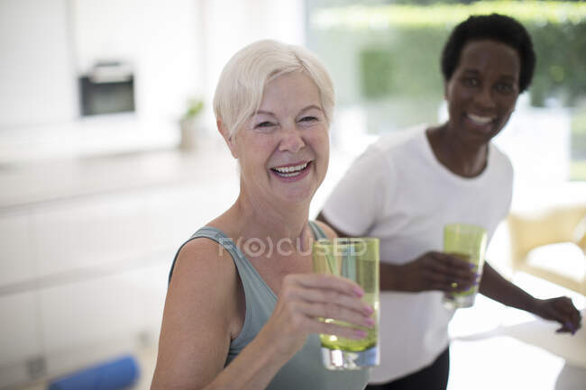 Portrait happy senior women friends drinking water at home — Stock Photo