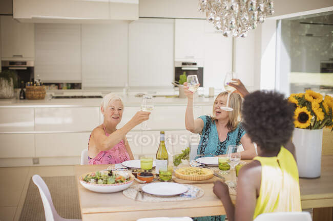 Joyeuses femmes âgées amis griller des verres à vin au déjeuner — Photo de stock
