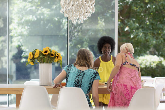 Happy senior women friends enjoying lunch at dining table — Stock Photo