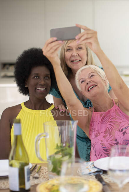 Happy senior women friends taking selfie at lunch — Stock Photo