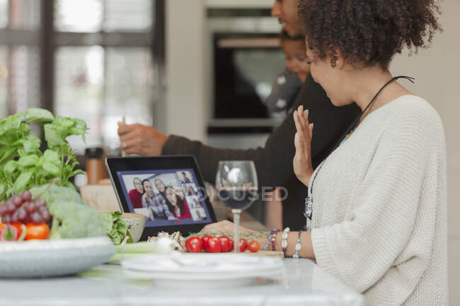 Family cooking and video chatting with friends on digital tablet — Stock Photo