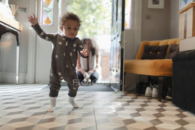 Cute baby girl in star pajamas learning to walk at home — Stock Photo