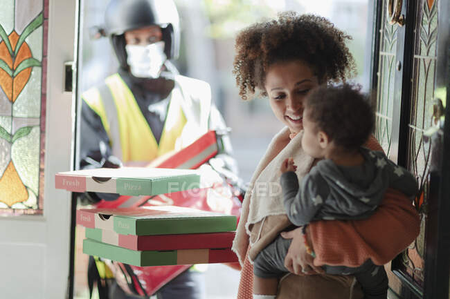 Mutter und kleine Tochter erhalten Pizzalieferung vor Haustür — Stockfoto