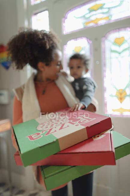 Mère et bébé fille recevant la livraison de pizza à la porte d'entrée — Photo de stock
