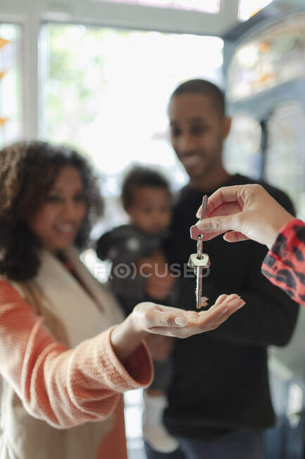Family receiving new house keys from realtor — Stock Photo