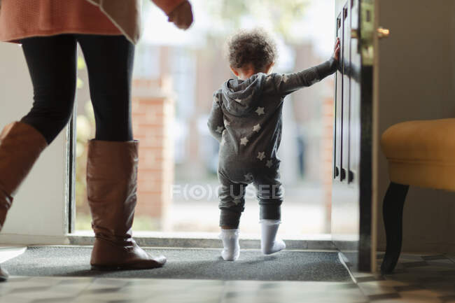 Mãe e bebê filha na porta da frente aberta — Fotografia de Stock