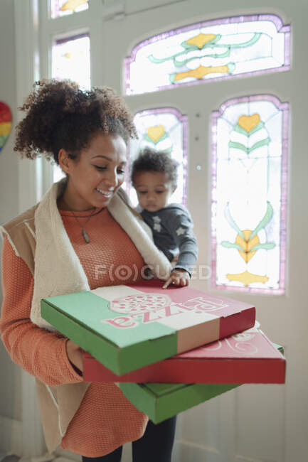 Мати і дитина дочка отримують доставку піци біля вхідних дверей — стокове фото