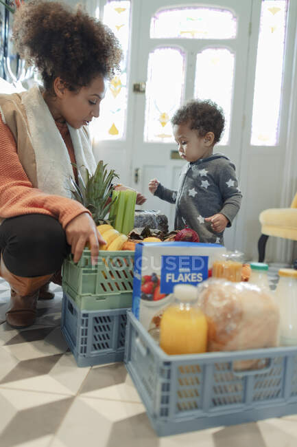 Mãe e bebê filha recebendo entrega de supermercado em casa — Fotografia de Stock