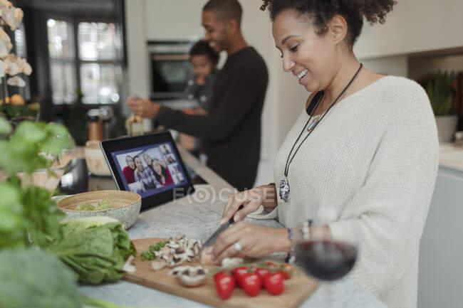 Mulher feliz cozinhar e vídeo bate-papo no tablet digital na cozinha — Fotografia de Stock