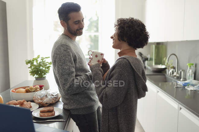 Happy couple talking in morning kitchen — Stock Photo