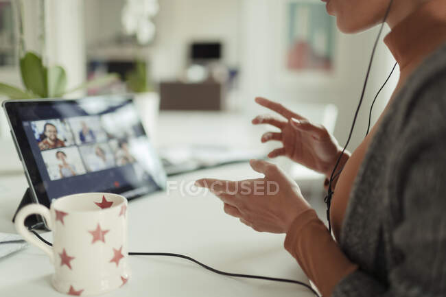 Mulher videoconferência com colegas com tablet digital em casa — Fotografia de Stock