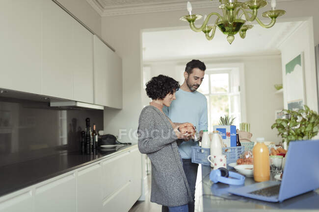 Entrega de mercearia de descarga de casal no balcão da cozinha — Fotografia de Stock