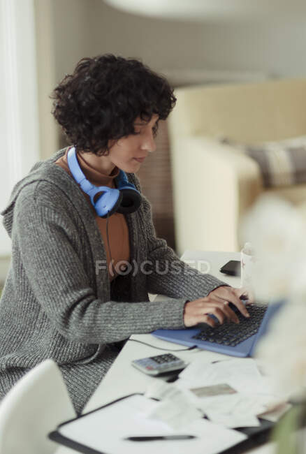 Женщина, работающая из дома за ноутбуком — стоковое фото