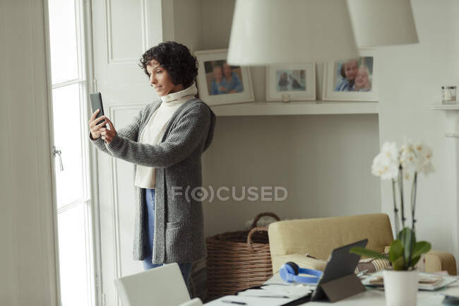 Woman video chatting with smart phone at home — Stock Photo