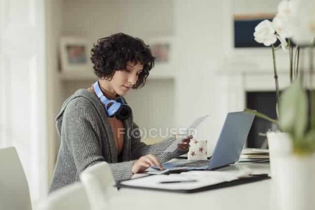 Woman working from home at laptop on dining table — Stock Photo