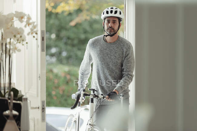 Человек с велосипедом возвращается домой через парадную дверь — стоковое фото