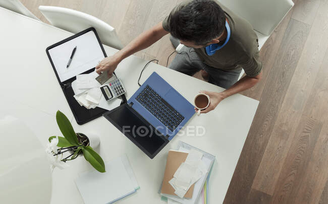 Homem com recibos de pagamento de contas no laptop — Fotografia de Stock