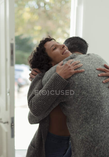 Felice coppia che abbraccia alla porta d'ingresso — Foto stock