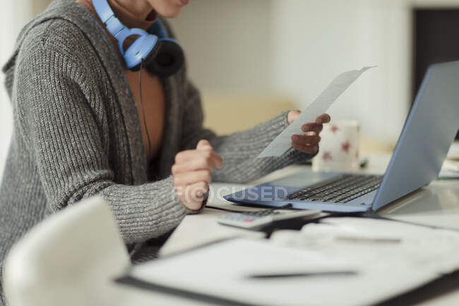 Жінка з чеком оплачує рахунки в ноутбуці — стокове фото