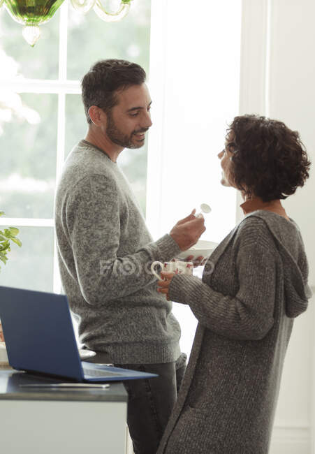 Happy couple talking and working from home in kitchen — Stock Photo
