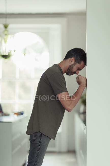 Uomo frustrato con pugni stretti appoggiati al muro — Foto stock