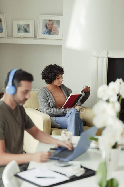 Paar liest und bezahlt Rechnungen online zu Hause — Stockfoto