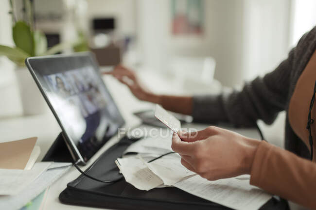 Mujer cercana con tarjeta de crédito pagando facturas en la tableta digital - foto de stock