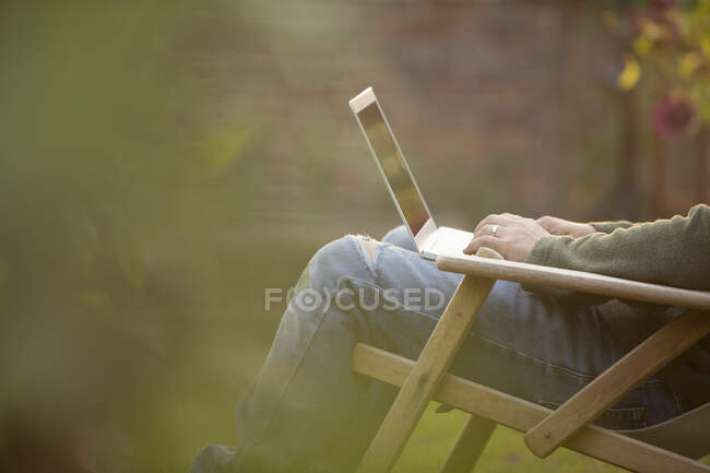 Человек с ноутбуком в саду — стоковое фото