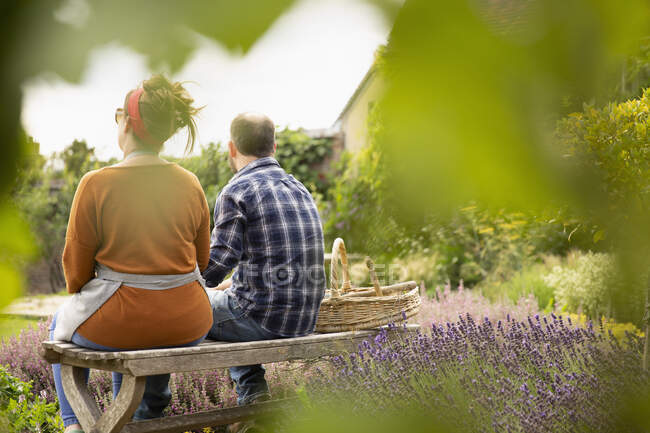 Пара відпочиває від садівництва на сонячному літньому подвір'ї — стокове фото